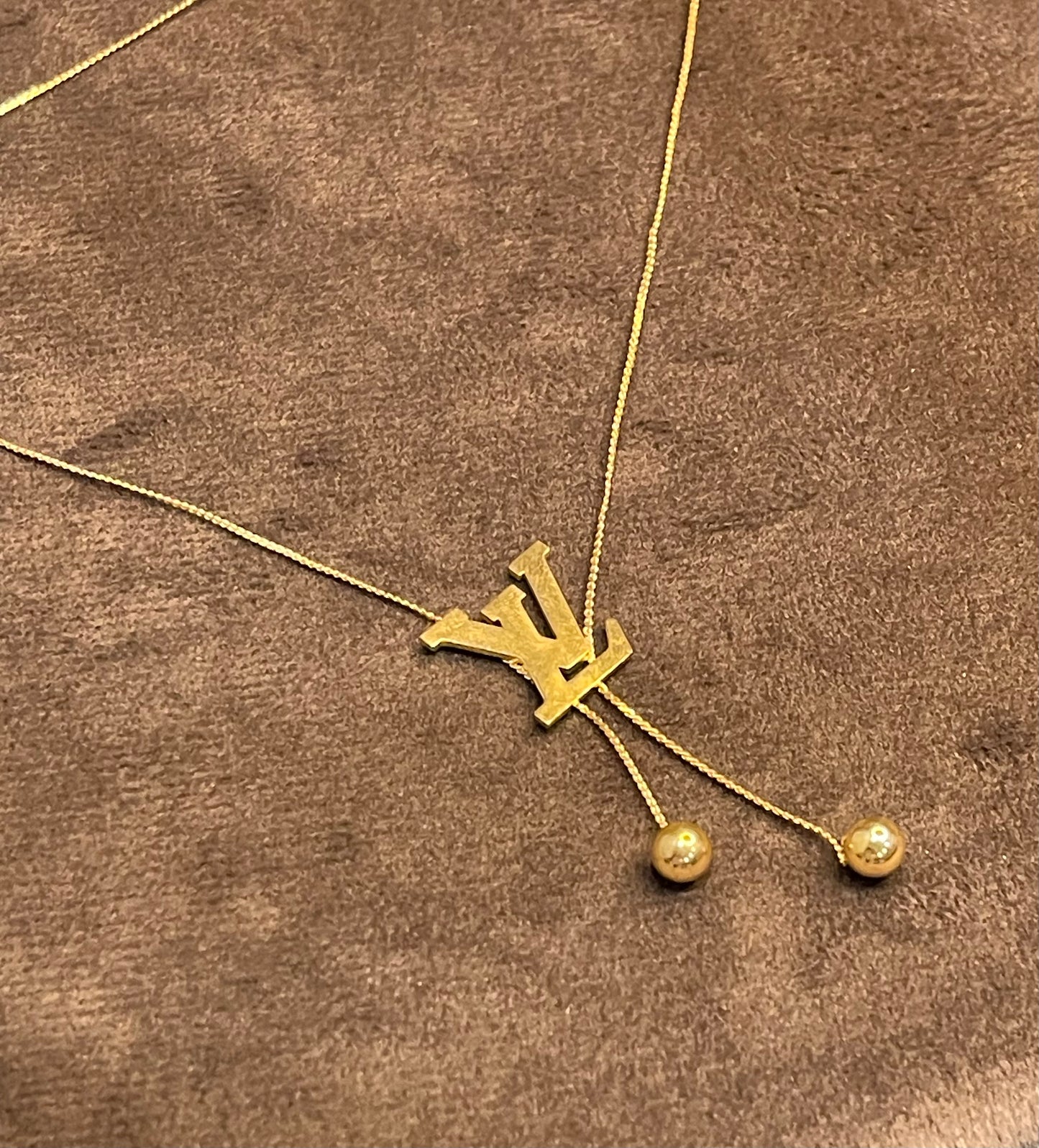 Gold Necklace with a Louis Vuitton (LV) logo.