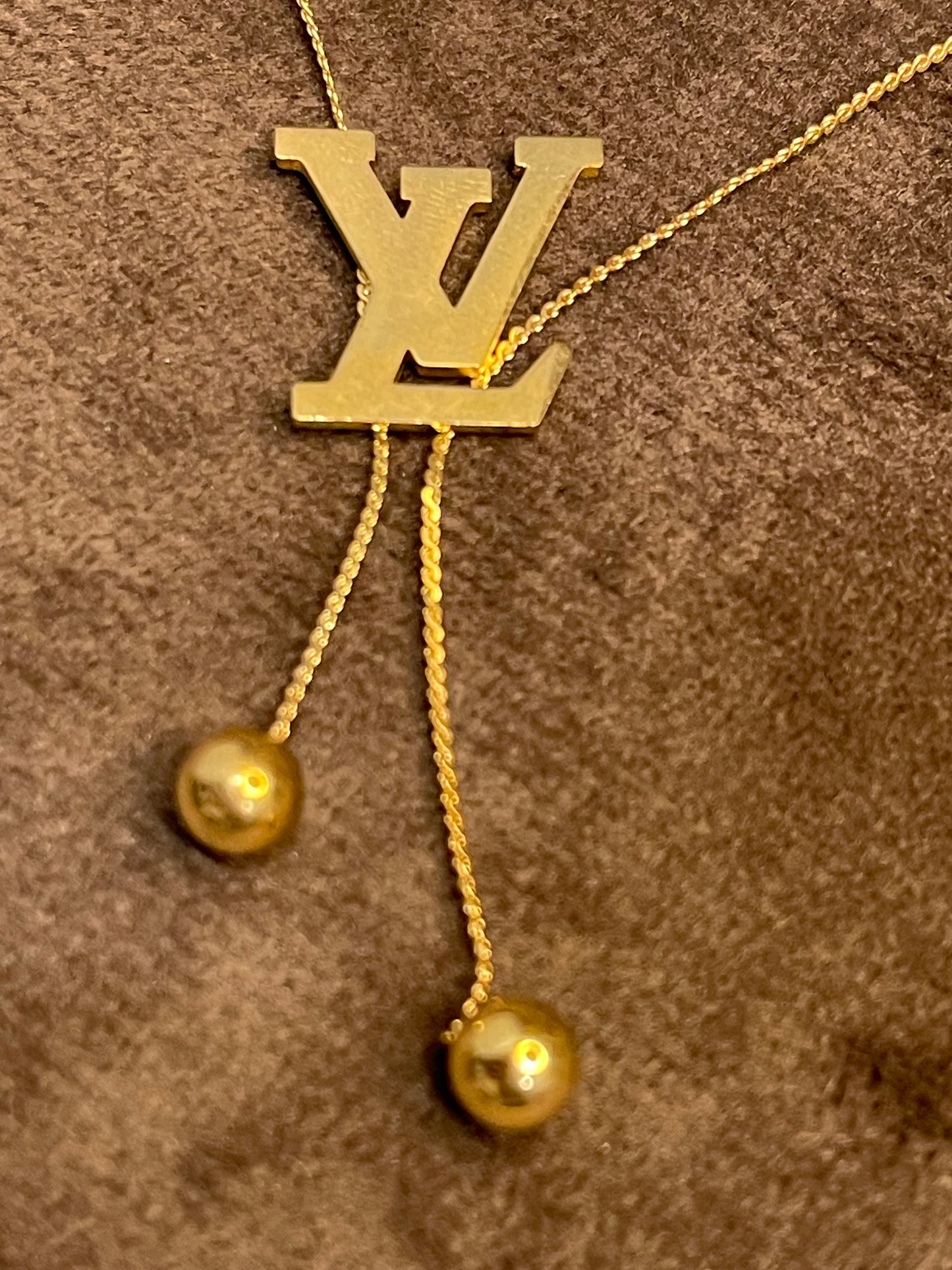 Gold Necklace with a Louis Vuitton (LV) logo.