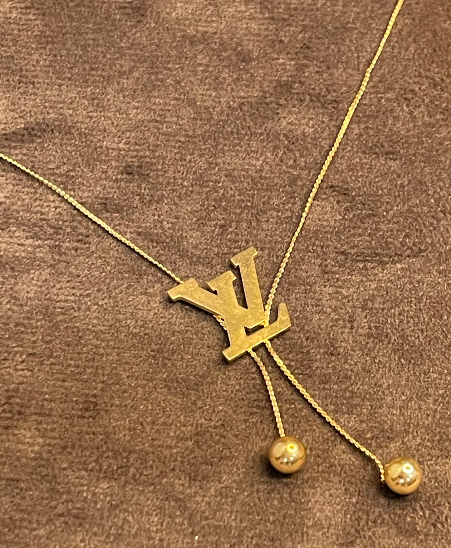 Gold Necklace with a Louis Vuitton (LV) logo.