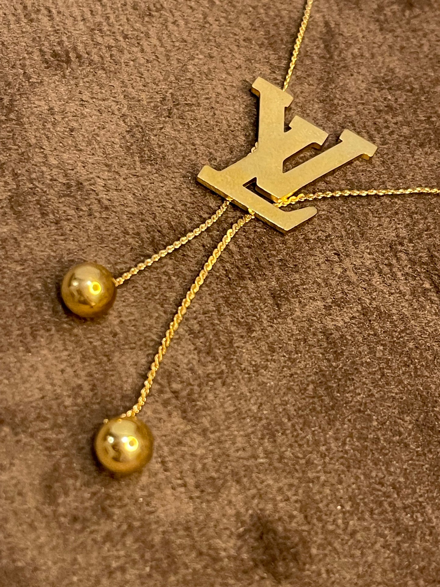 Gold Necklace with a Louis Vuitton (LV) logo.